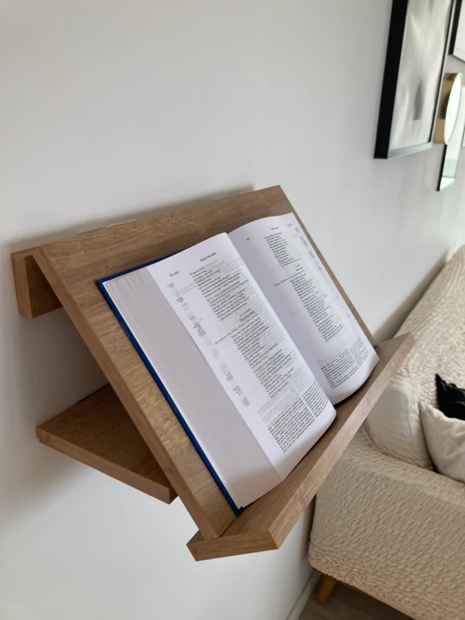Rozłożona półka Pluteus z Biblią, na ścianie.